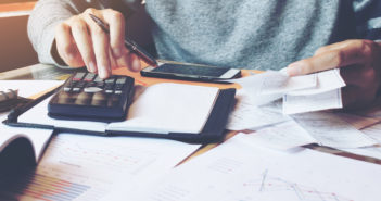 Financial Losses Linked to Greater Risk of Death Man using calculator and calculate bills in home office.