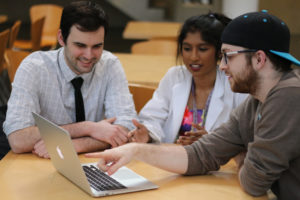 Tasmeen Hussain works with classmates Matt Antalek (left) and Anthony Gacita (right) on the SynapseGarden, an online app they developed for medical students to write questions for each other that they can then use to practice for tests.