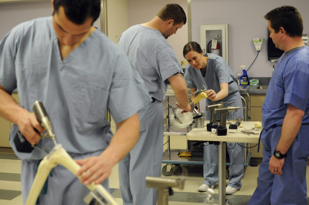 Students familiarize themselves with the tools they will use once during their orthopaedic surgery residencies, including practicing using them on synthetic bones. 