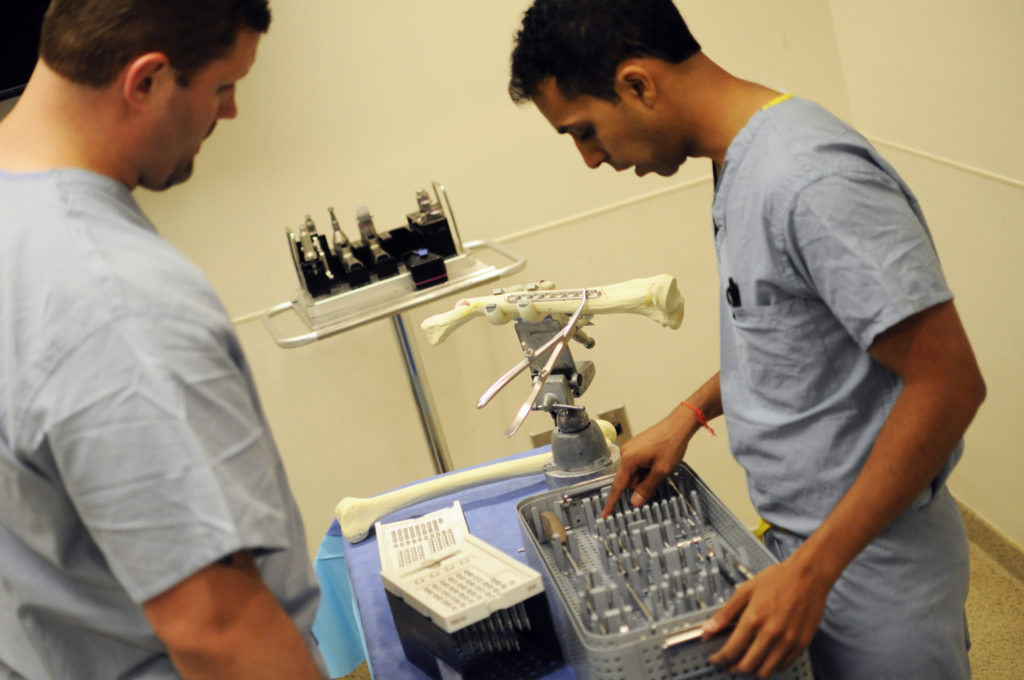 (Left to right) Matthew Beal, MD, assistant professor of Orthopaedic Surgery, demonstrates the tools that are used when repairing fractures for Nitin Goyal, ’16 MD. 