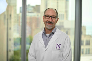 Dan Foltz, PhD, in a white lab coat