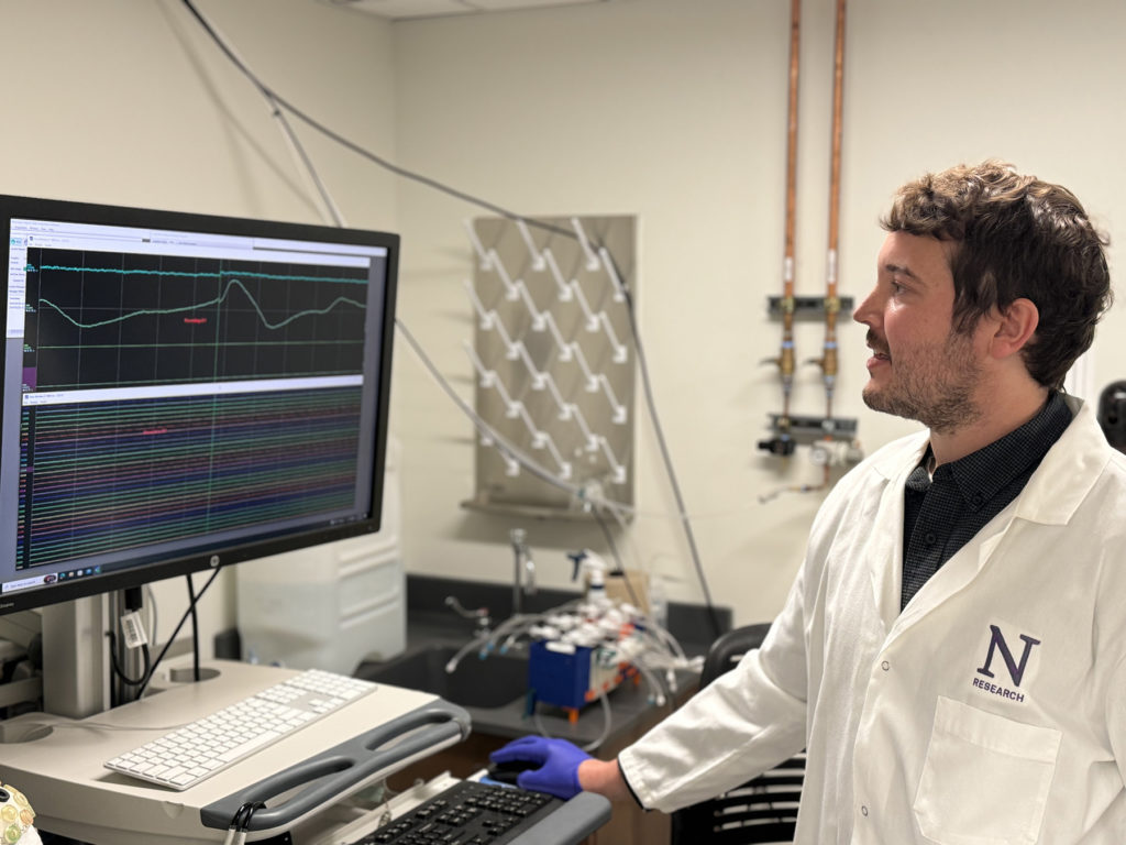 Corresponding study author Andrew Sheriff looks at a monitor examining brain waves of someone as they breathe in and out.