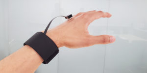 A photo of a new device on a person's hand that applies dynamic forces in any direction to simulate a more realistic sense of touch.
