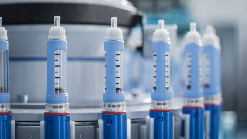 Close-up of Blue Medical Injector on Conveyor Line during Production Process at Modern Pharmaceutical Factory.