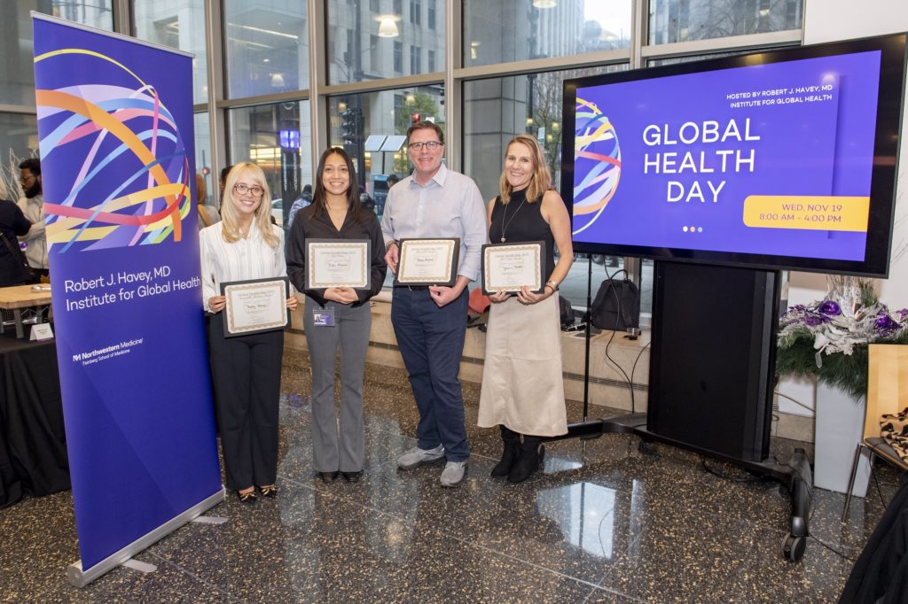 Global Health Day presentation winners and honorable mentions stand with their awards and pose for a photo. 