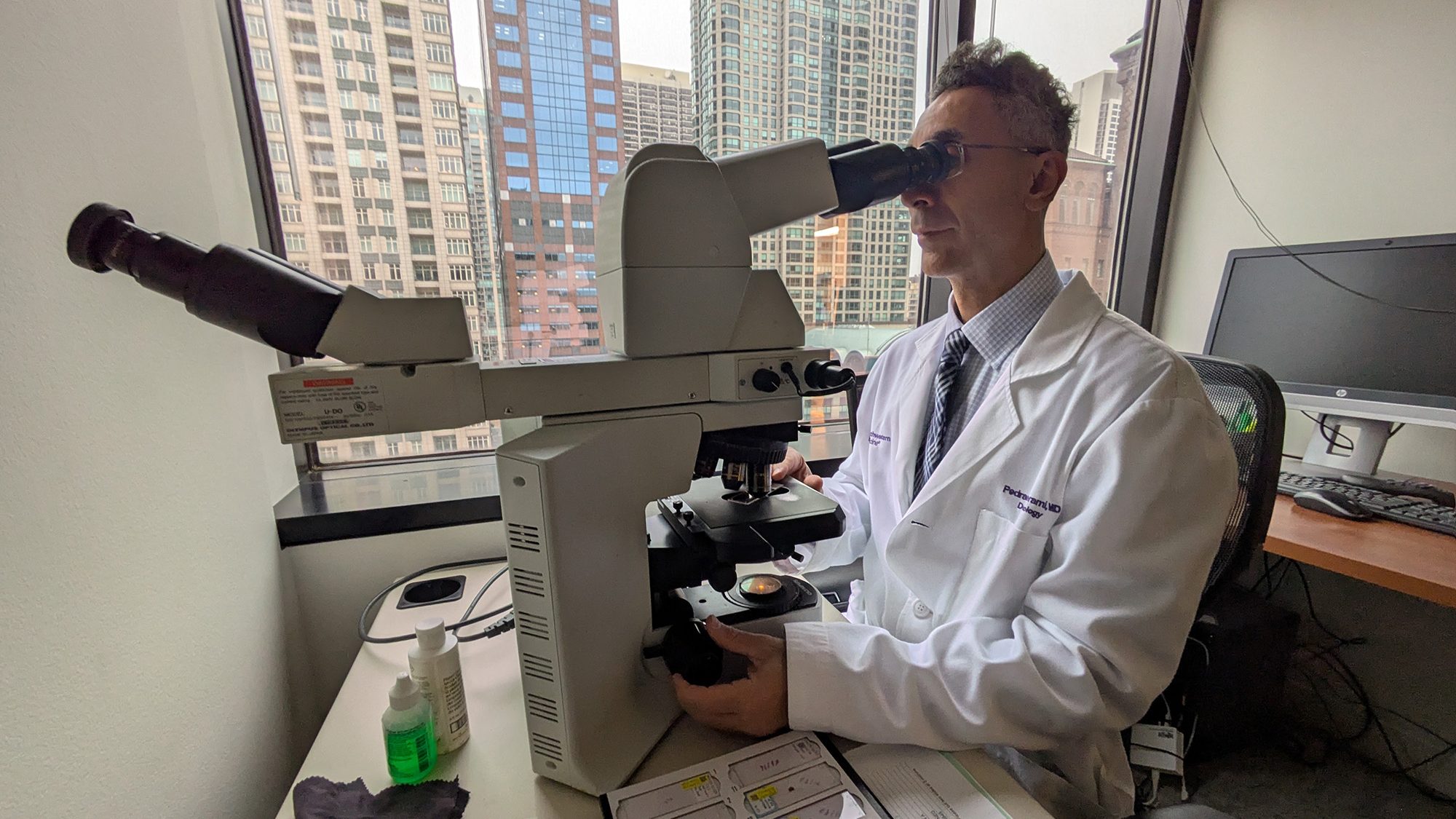 Study author Pedram Gerami, MD, the IDP Foundation Professor of Skin Cancer Research in the Department of Dermatology, looking at a skin biopsy in his office.