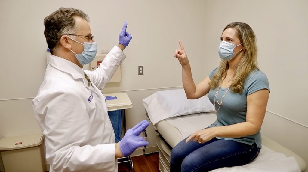 Igor Koralnik, MD, the Archibald Church Professor of Neurology, meets with a patient in the Comprehensive COVID-19 Center at Northwestern Medicine.