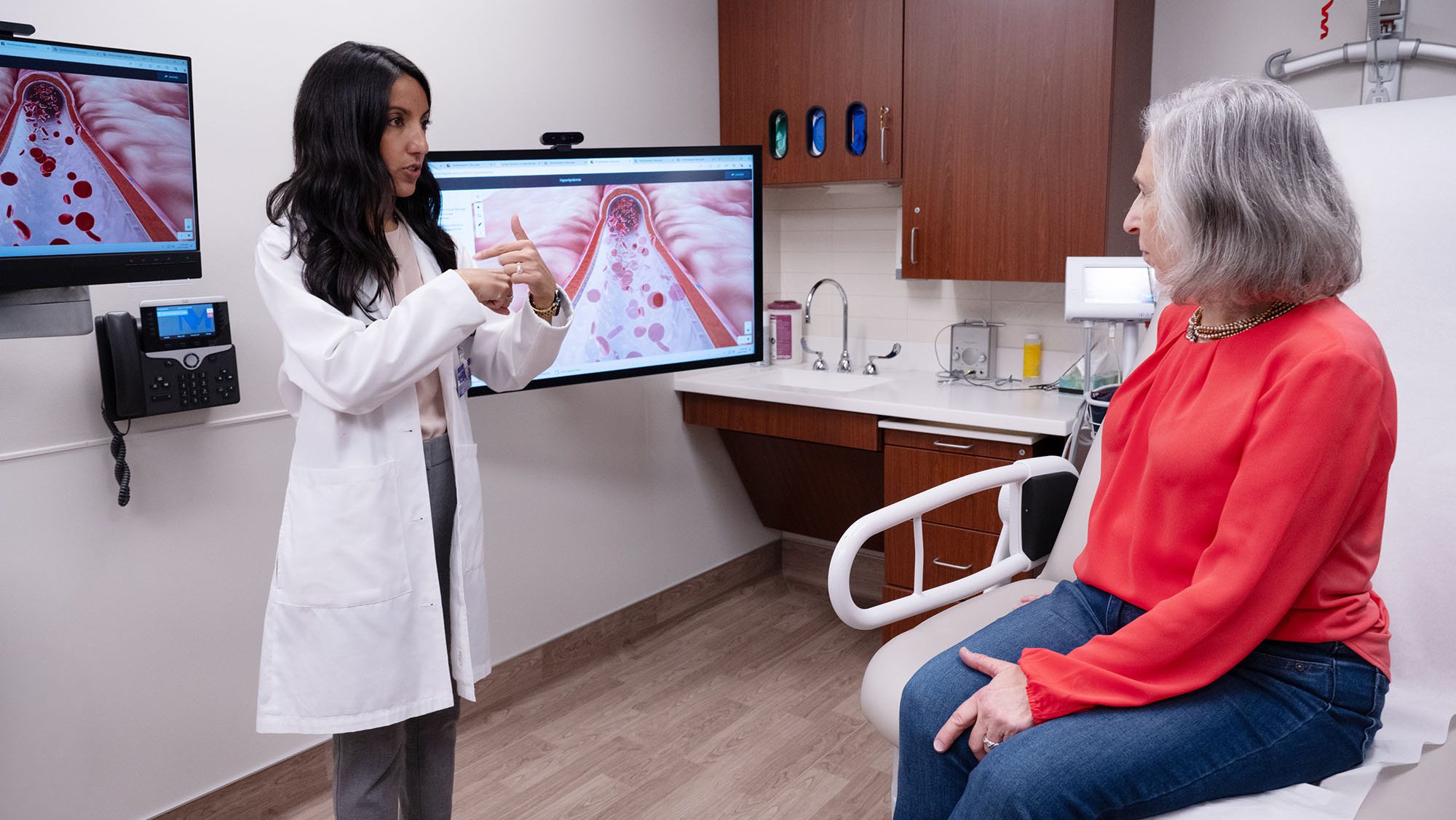 Priya Freaney, MD, assistant professor of Medicine in the Division of Cardiology, speaking to a patient at Bluhm Cardiovascular Institute at Northwestern Memorial Hospital in Chicago.