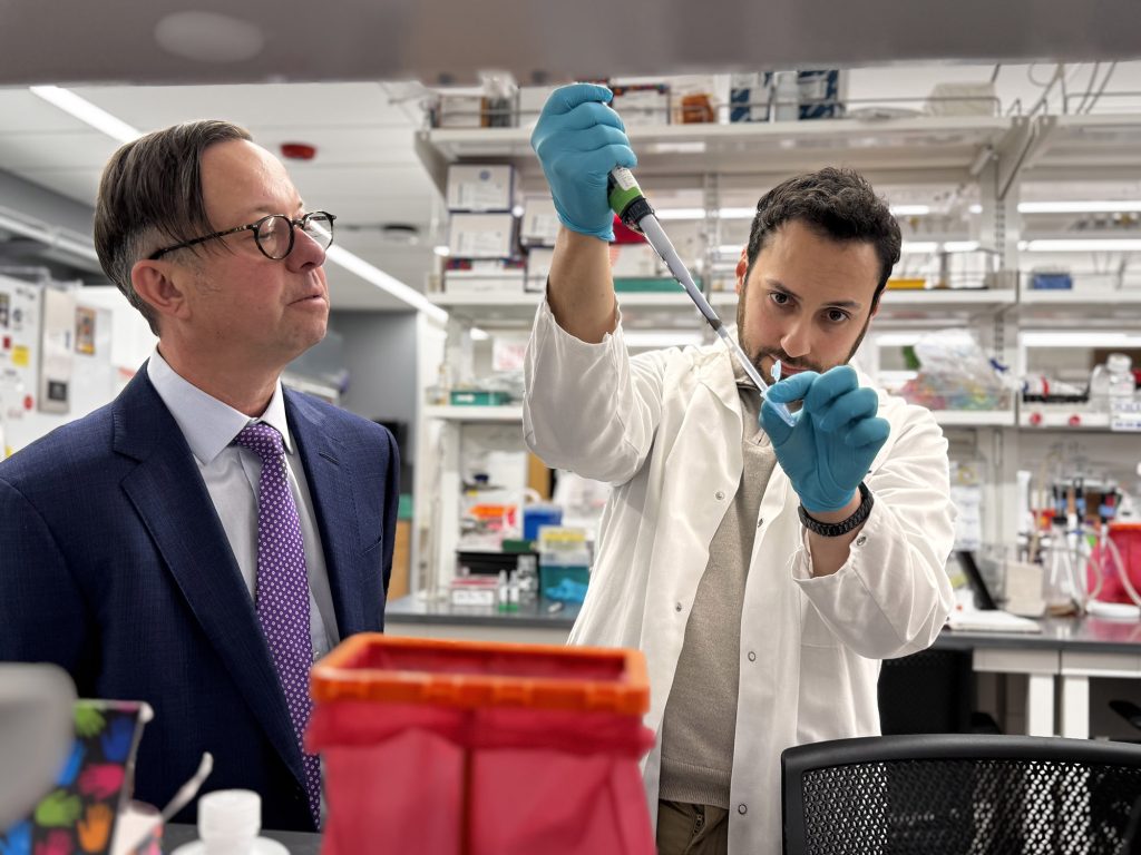 Marc Dos Santos (right) pipettes in the lab of Peter Penzes (left) on Northwestern's Chicago campus. (Credit: Kristin Samuelson, Northwestern University)