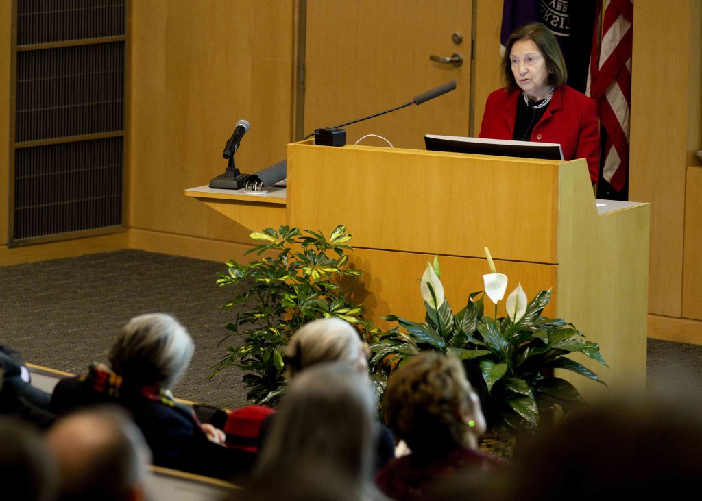 Svetlana Mojsov, PhD, delivers her lecture at a podium to a packed auditorium.
