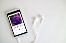 Breakthroughs podcast playing on iPhone with earbuds plugged into it