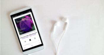 Breakthroughs podcast playing on iPhone with earbuds plugged into it
